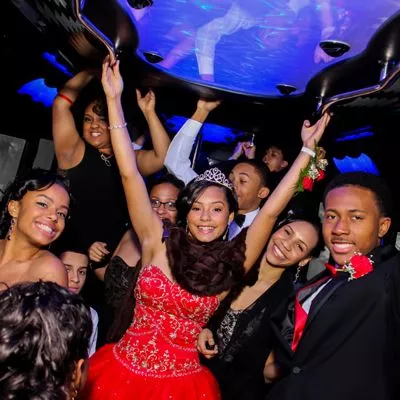 Girl celebrating her Quinceanera with her friends inside a limo coach party bus. 