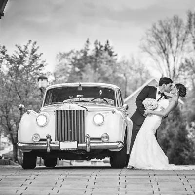 Bride and groom next to Rolls Royce Silver Cloud II limo